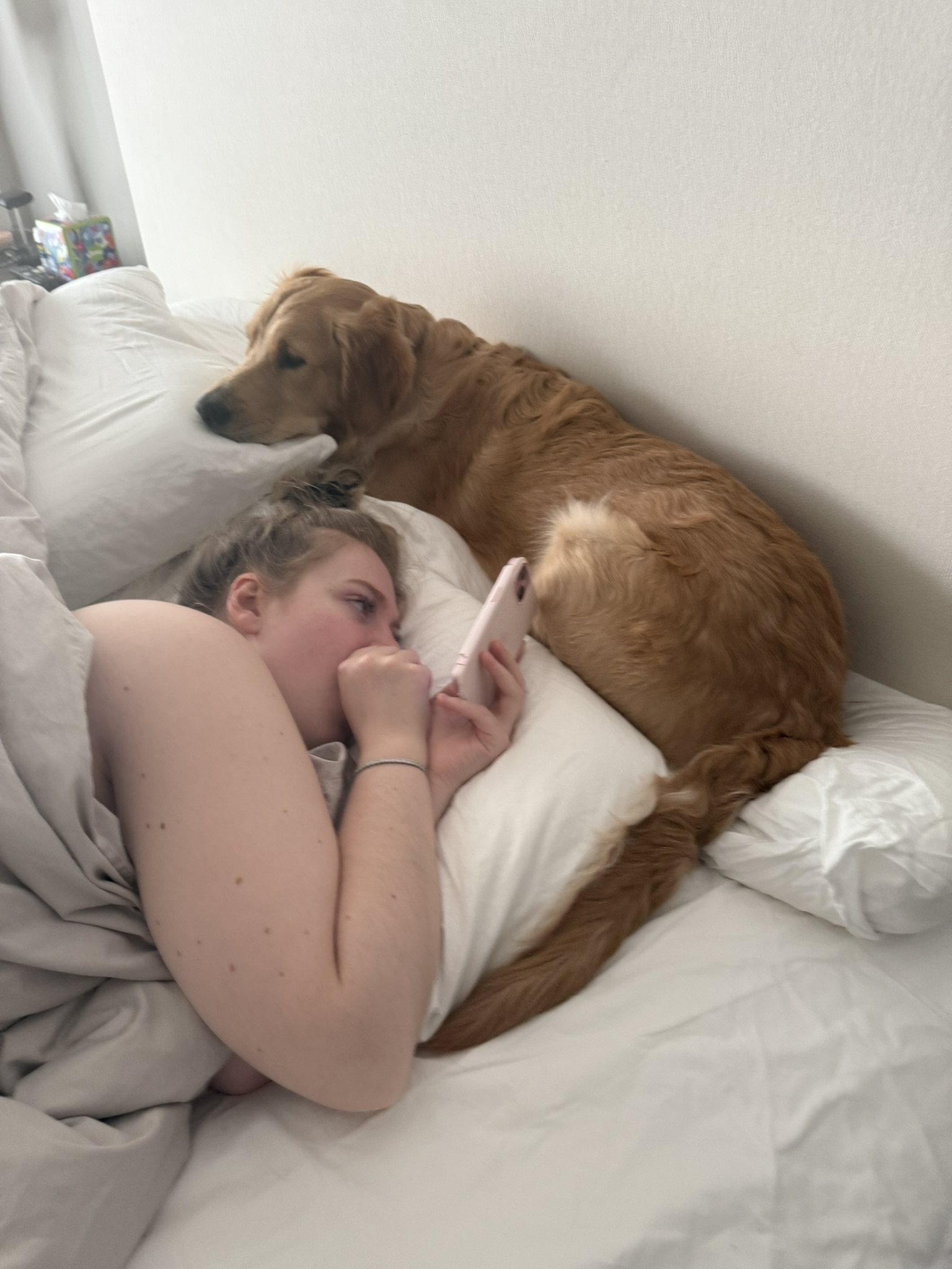 Winnie lying in bed next to his mom.